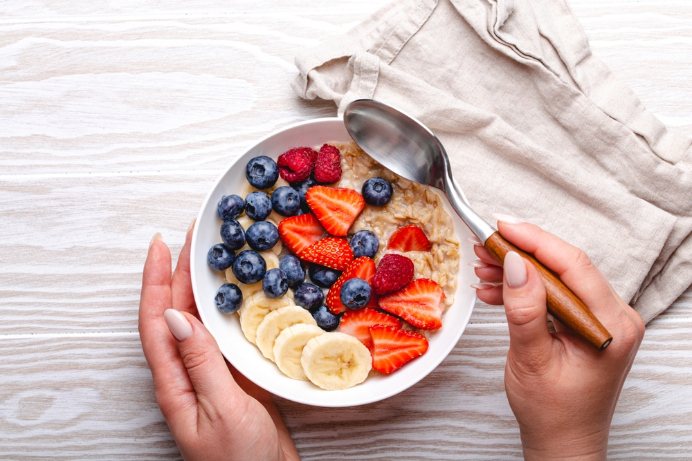 Tigela de mingau de aveia com banana, morango e mirtilos com um guardanapo ao lado