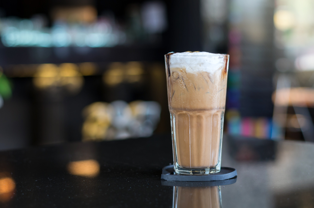 foto de um copo de capuccino em cima de uma mesa